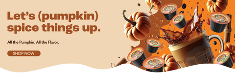 a banner with a close up shot of a glass coffee mug splashing coffee, mini pumpkins, coffee beans, crazy cup pods, and spices everywhere, with the caption "Let's (pumpkin) spice things up. All the spice, all the flavor" and a brown shop now button.